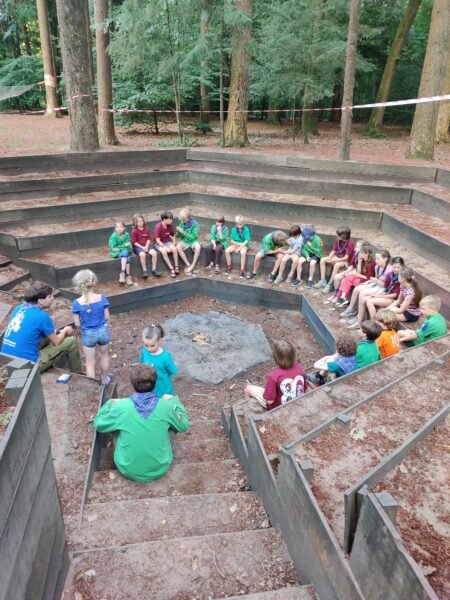 De Welpen spelen een potje weerwolven in de kampvuurkuil om het lampvuur