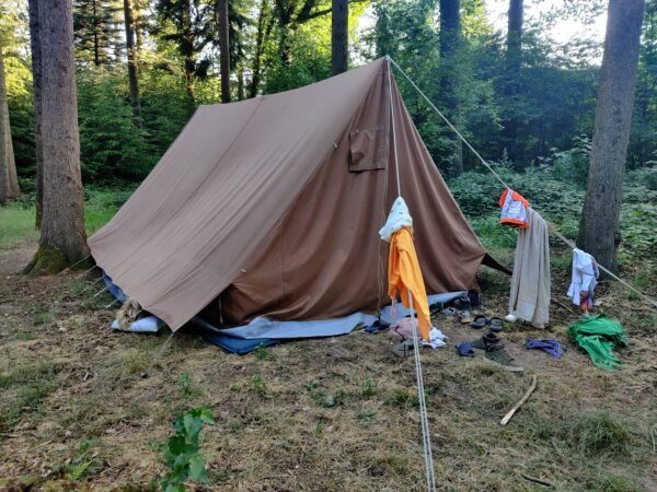 Een van de Welpen slaapt met het hoofd uit de tent