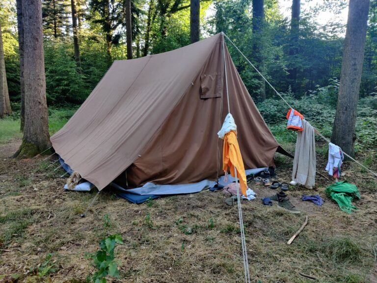 Een van de Welpen slaapt met het hoofd uit de tent